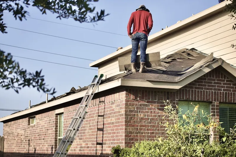 Professional roofer working on a residential roof in Outlook
